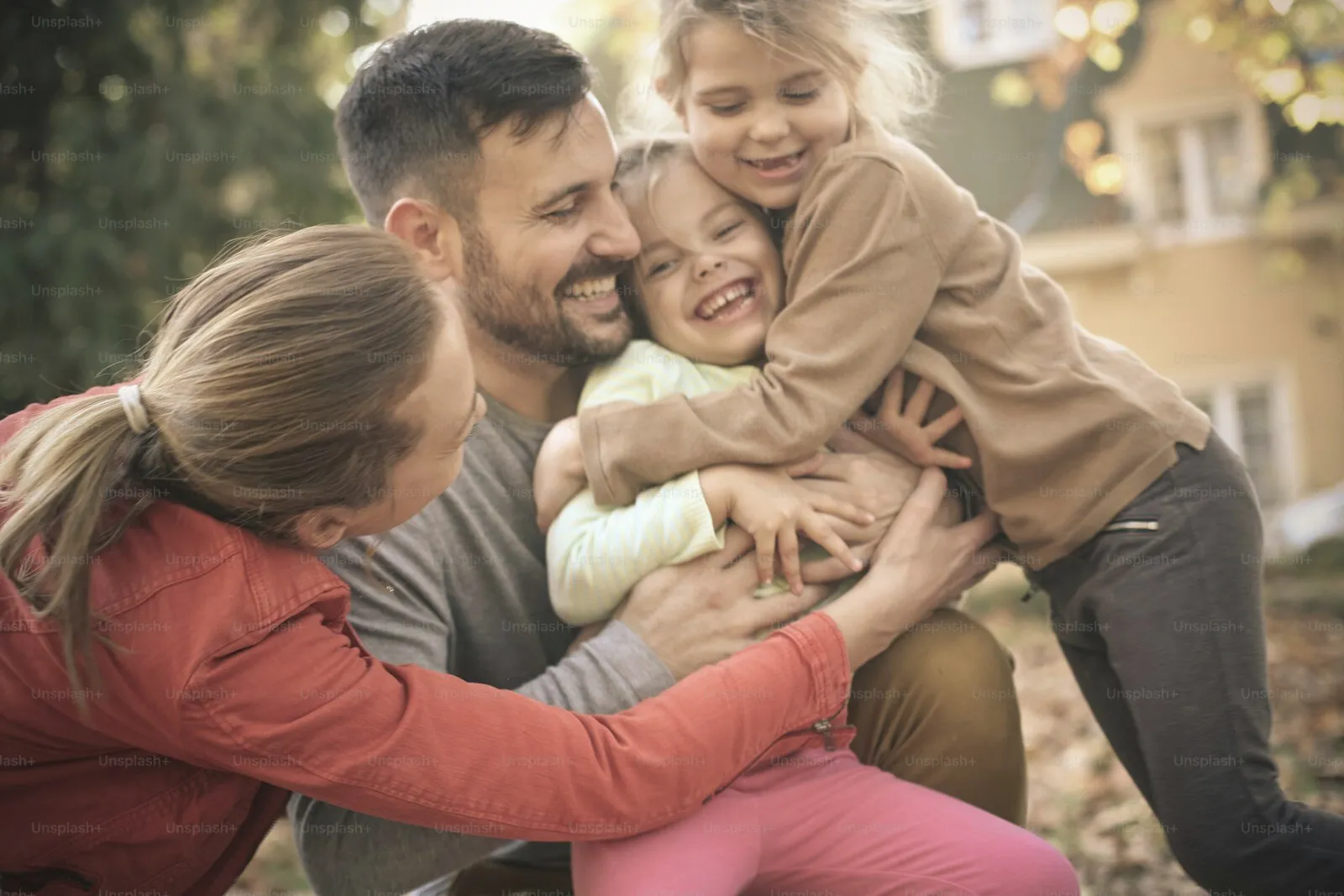 A family holding each other close outdoors