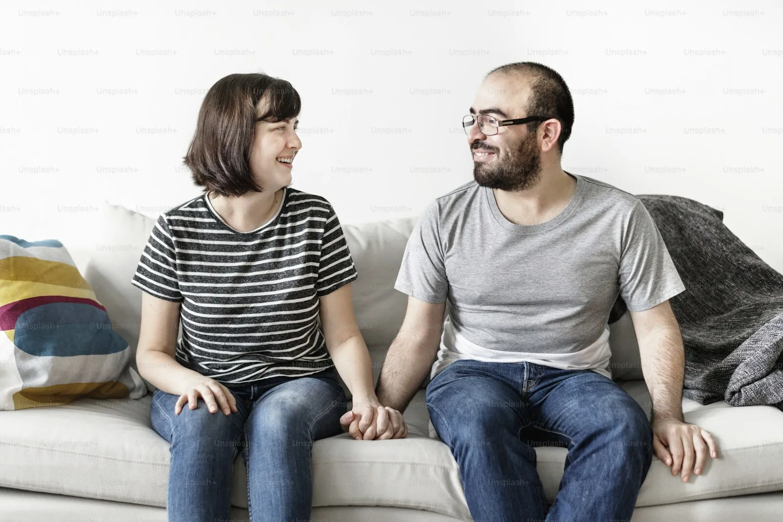 A couple sitting together on a sofa, turned toward each other