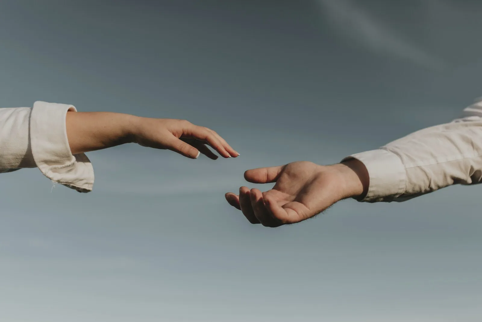 Two hands reaching toward one another