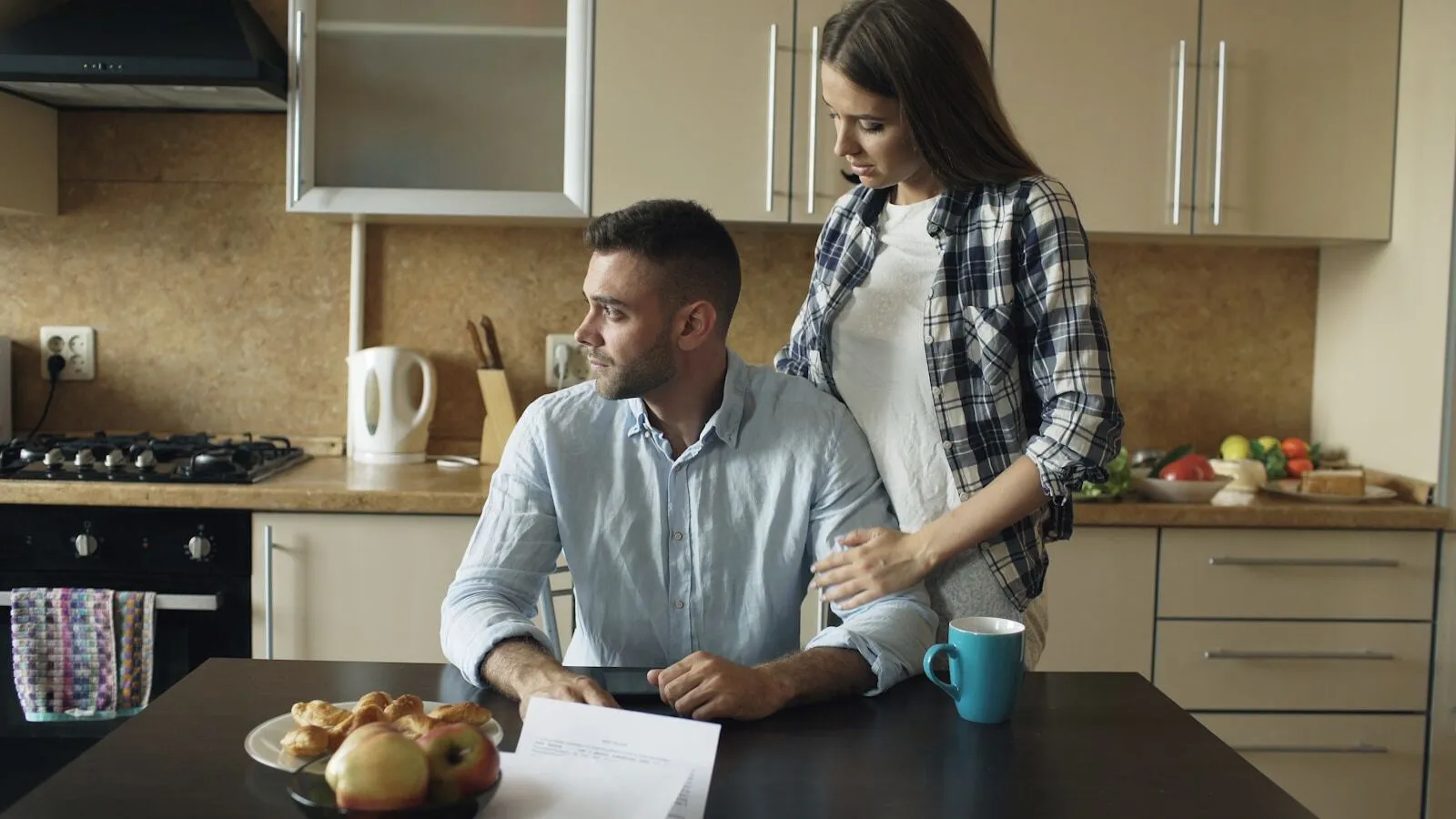 Two people talking across a kitchen counter