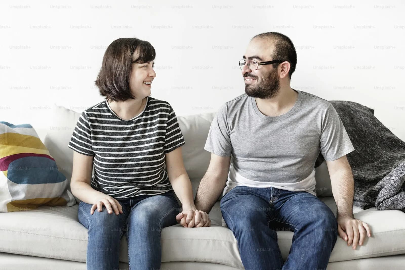 A couple sitting together on a sofa, turned toward each other