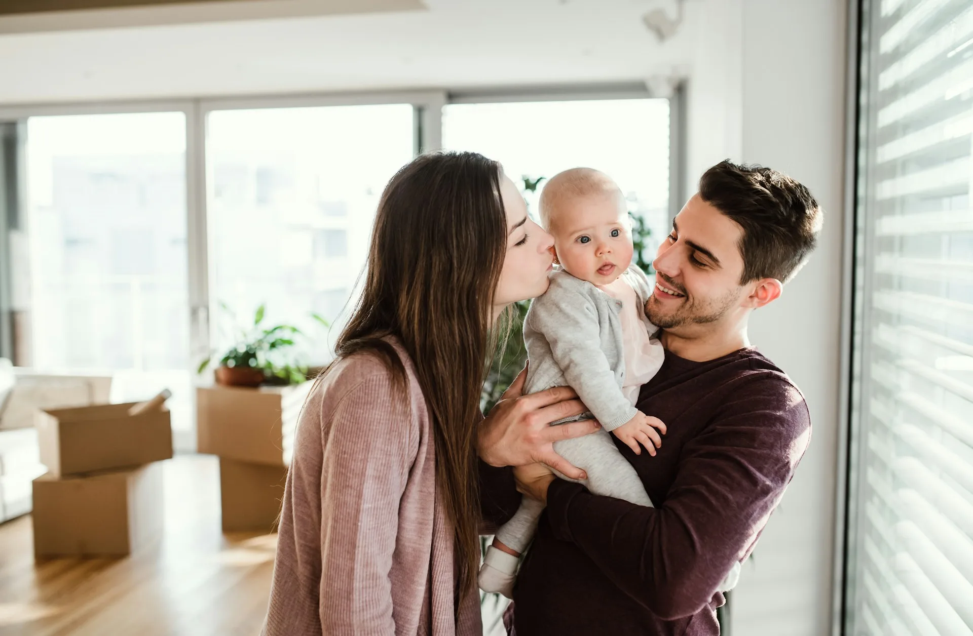 A couple holding their baby together at home
